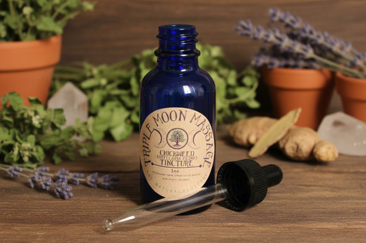 Bottle of Triple Moon Massage oil with a label on a green background
