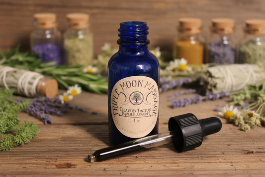 Blue glass bottle with a dropper labeled 'Moon Massage' on a green background